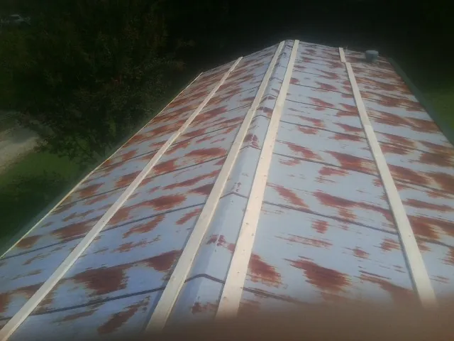 Rusted metal roof panels with new wood purlins before replacement — Storm Damage Roof Repair in North Scituate by Roofing Brothers