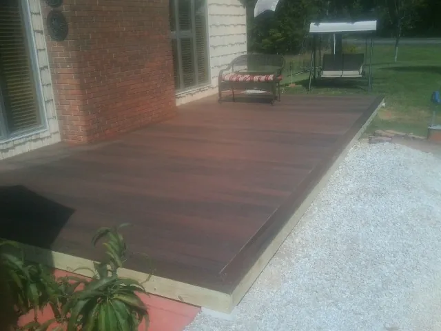 Freshly stained wood deck built against a brick home in North Scituate
