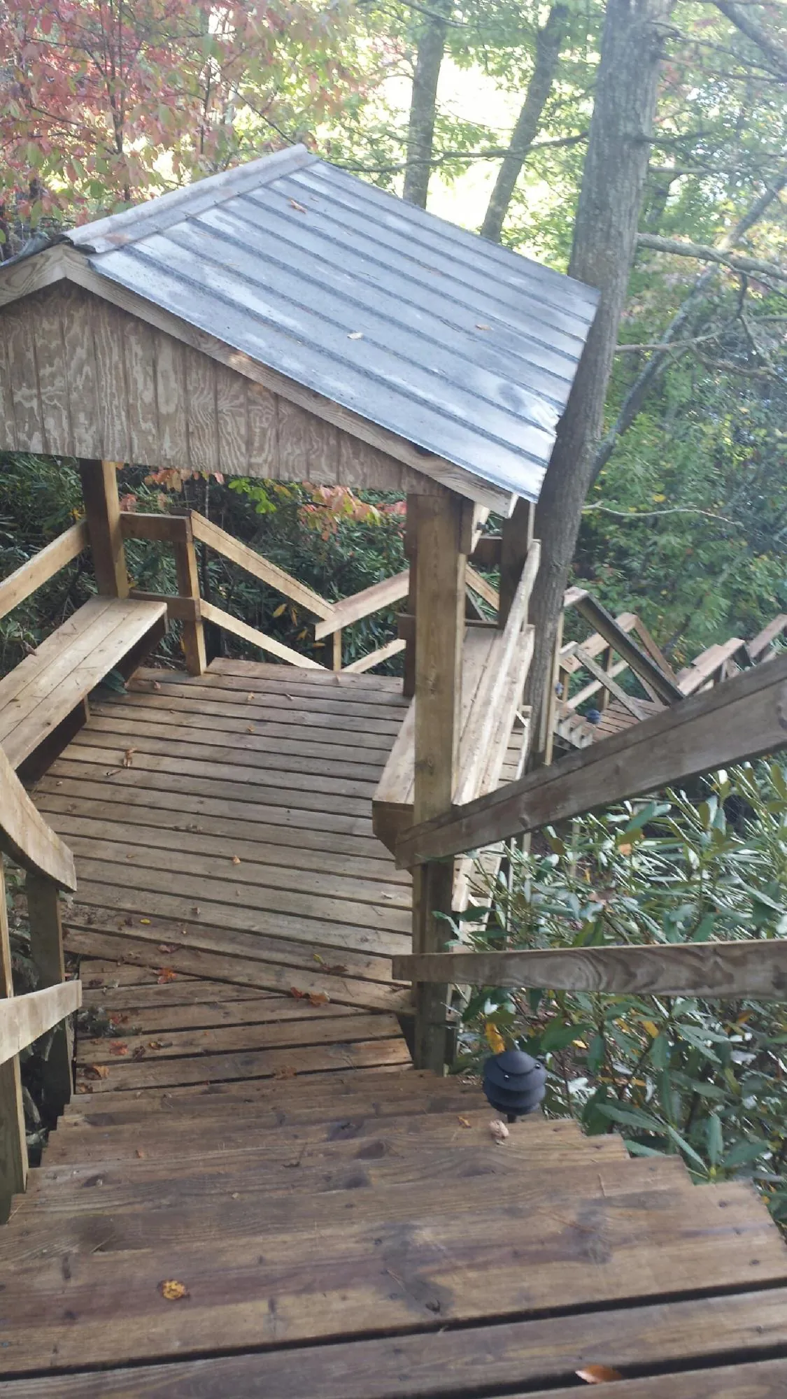 Metal roofed shelter over wooden steps on a wooded walkway — Skylight Repair & Installation work by our crew in North Scituate